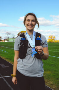 Erin our South Portland Store Manager holding her half marathon medallion.